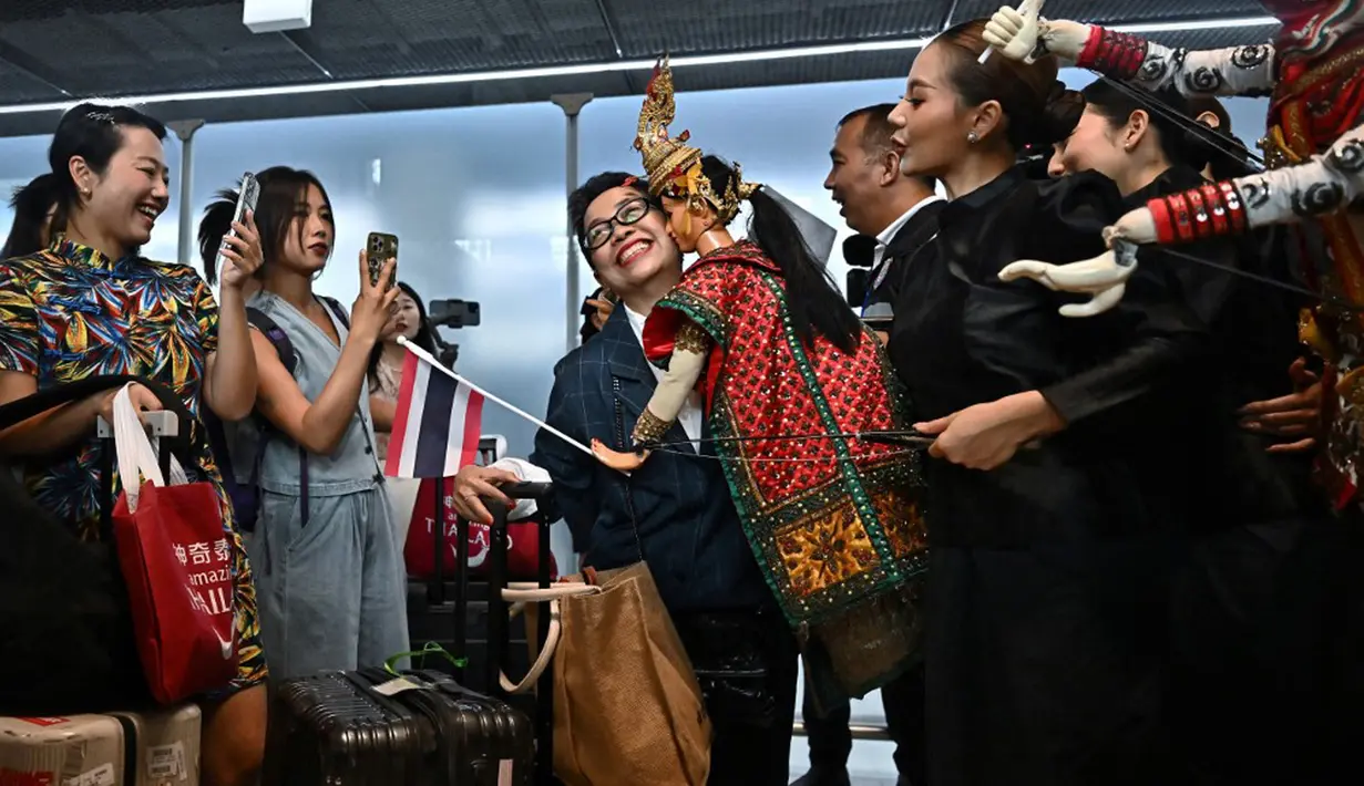 <p>Turis China disambut oleh penari di gerbang kedatangan Bandara Internasional Suvarnabhumi, Bangkok, Thailand, Senin (25/9/2023). Turis China yang mendarat di Bangkok disambut bak tamu VIP. (Lillian SUWANRUMPHA/AFP)</p>