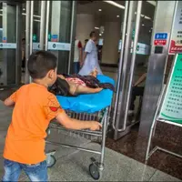 Bocah ini rela mengantarkan kakaknya yang merintih kesakitan ke rumah sakit. | Sumber Foto: facebook.com/chinadaily