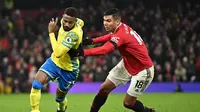 Pemain Manchester United, Casemiro (kanan), berduel dengan striker Nottingham Forest,  Emmanuel Dennis, pada laga Liga Inggris 2022/2023, di Stadion Old Trafford, Rabu (28/12/2022) dini hari WIB. (AFP/Oli Scarff)