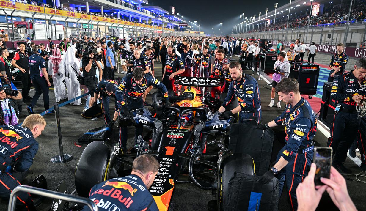 Tim Red Bull Racing sedang mempersiapkan mobil Max Verstappen sebelum melakukan balapan pada Formula 1 GP Qatar 2025 di Sirkuit Lusail, Lusail, Qatar, Minggu (30/11/2025) waktu setempat. (AFP/Andrej Isakovic)