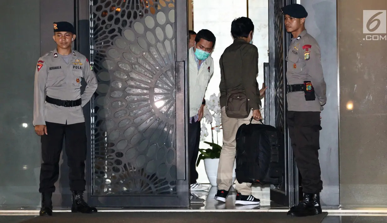 Dua penyidik KPK masuk ke dalam rumah tersangka Ketua DPR RI Setya Novanto dengan membawa tas warna hitam di Jalan Wijaya 13 No 19, Jakarta Selatan, Rabu (15/11). (Liputan6.com/Johan Tallo)