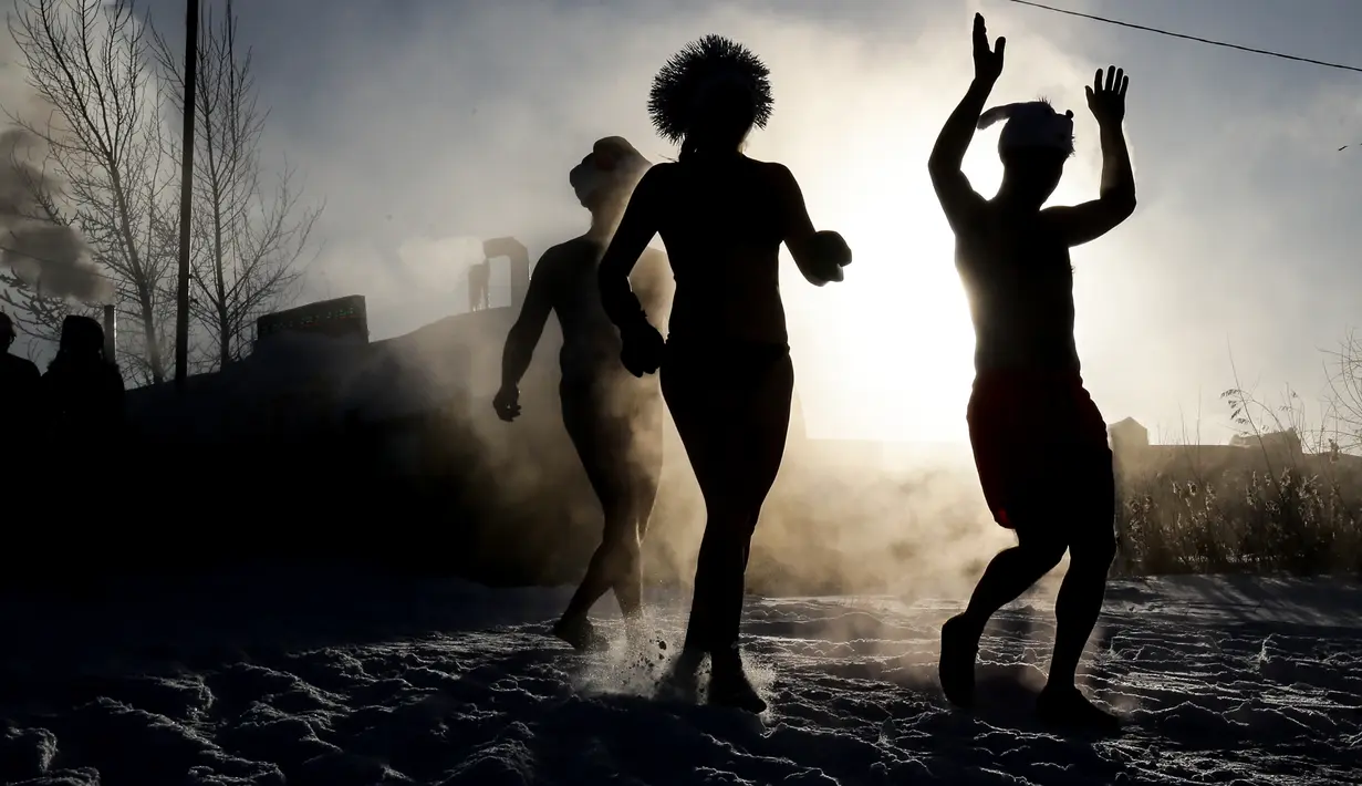 Anggota klub renang es berenang di air es saat suhu turun hingga minus 34 derajat celcius, di kota Novosibirsk, Siberia, Rusia, Sabtu (26/12/2020). Saat musim dingin datang, warga di Rusia justru mendatangi air yang dingin untuk berenang. (Rostislav NETISOV/AFP)