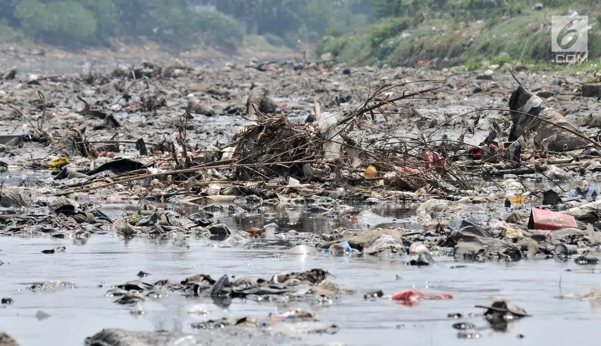 Tumpukkan sampah yang muncul di permukaan Kanal Banjir Barat, Jakarta, Selasa (16/7/2019). Kemarau sejak dua bulan terakhir ini menyebabkan sampah-sampah yang mengendap di dasar sungai muncul ke permukaan sehingga menimbulkan bau tak sedap. (merdeka.com/Iqbal S Nugroho)