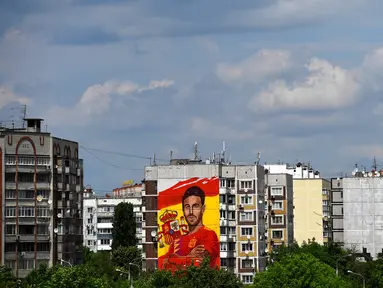 Sebuah mural raksasa begambar bek Spanyol Sergio Ramos terlihat di sebuah bangunan perumahan di Krasnodar, Rusia, Rabu (6/6). Ramos mendapat sambutan hangat di Krasnador. (Pierre-Philippe MARCOU/AFP)