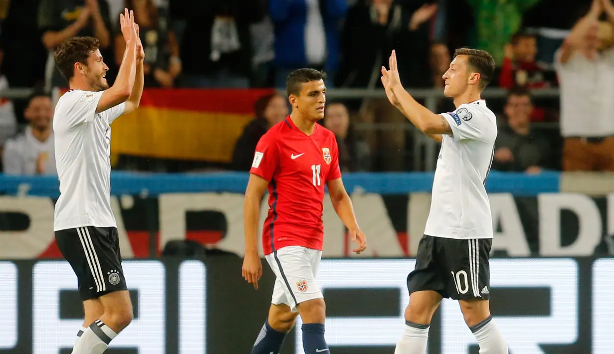 Gelandang Jerman, Mesut Ozil (kanan) melakukan selebrasi bersama rekannya Jonas Hector usai mencetak gol ke gawang Norwegia pada Kualifikasi Piala Dunia 2018 di Stuttgart, Jerman,(4/9). Jerman menang telak atas Norwegia 6-0. (AP Photo/Michael Probst)