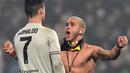 Suporter Juventus yang masuk ke lapangan dan menghampiri Cristiano Ronaldo pada laga lanjutan Serie A yang berlangsung di stadion Mapei, Reggio Emilia, Senin (11/2). Juventus menang 3-0 atas Sassuolo. (AFP/Miguel Medina)