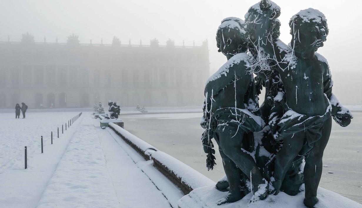 Sejauh ini, cuaca terdingin terjadi di Inggris, Prancis, dan Belanda. Tampak dalam foto, salju menyelimuti sebuah patung di tepi Midi bassin di taman Versailles, luar Kota Paris pada Selasa 6 Januari 2026. (GEOFFROY VAN DER HASSELT/AFP)