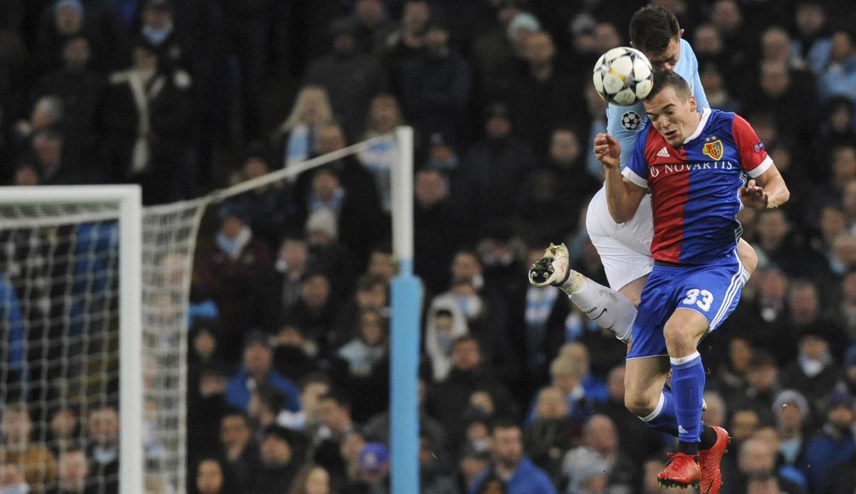 Bek Manchester City, Aymeric Laporte, duel udara dengan pemain FC Basel, Kevin Bua, pada laga Liga Champions di Stadion Etihad, Rabu (7/3/2018). Manchester City takluk 1-2 dari FC Basel. (AP/Rui Vieira)