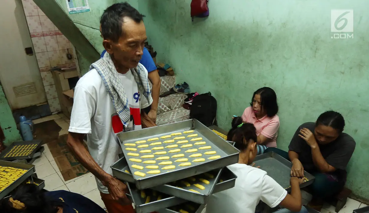 Pekerja memindahkan adonan kue kering saat proses pembuatan di industri rumahan kawasan Kwitang, Jakarta, Sabtu (18/5/2019). Penjualan kue kering jelang Lebaran meningkat hingga 50 persen dibanding hari-hari biasanya. (Liputan6.com/Herman Zakharia)