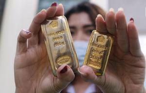 Petugas menunjukkan sampel logam mulia di Butik Emas Antam, Jakarta, Kamis, (23/7/2020). Usai cetak rekor ke posisi termahalnya di Rp 982 ribu, harga emas PT Aneka Tambang Tbk (Emas Antam) kembali turun Rp 5.000 menjadi Rp 977 ribu per gram pada perdagangan hari ini. (Liputan6.com/Angga Yuniar)