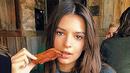 Aktris asal Amerika Emily Ratajkowski bahkan dapat menyantap sepotong daging asap dengan seksi dan elegan. (via people.com)