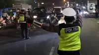 Polisi Lalu Lintas mengarahkan kendaraan untuk putar balik di titik penyekatan Jalan Raya Bogor, Jakarta, Sabtu (3/7/2021). Seiring diberlakukannya PPKM Darurat Jawa-Bali 3-20 Juli 2021, petugas melakukan penyekatan untuk menekan penyebaran virus COVID-19. (Liputan6.com/Helmi Fithriansyah)