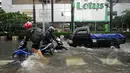 Para pengendara terpaksa mendorong motornya yang mati akibat banjir di kawasan Sarinah, Jakarta, Senin (9/2/2015). (Liputan6.com/Johan Tallo)