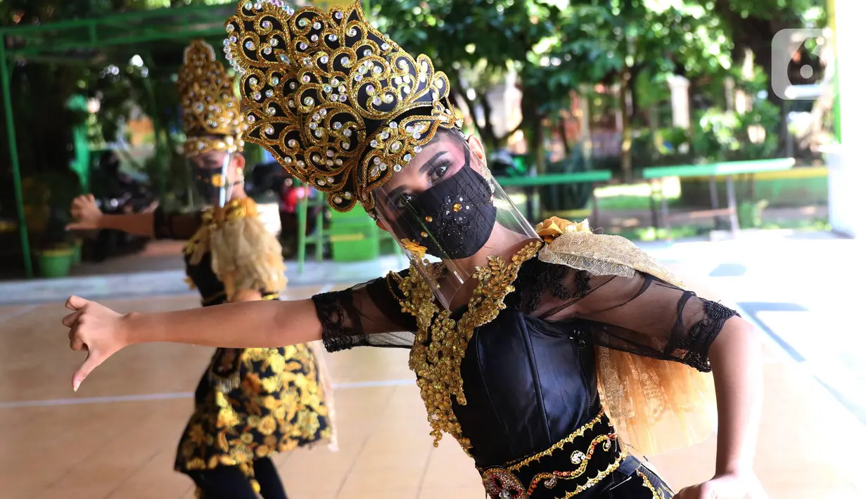 Penari tradisional dari Sanggar Eschoda melakukan latihan menggunakan masker dan pelindung wajah di Kota Tangerang, Jumat (12/6/2020). Para penari itu menerapkan protokol kesehatan jelang new normal atau tatanan hidup normal, sekaligus sebagai upaya pencegahan Covid-19. (Liputan6.com/Angga Yuniar)