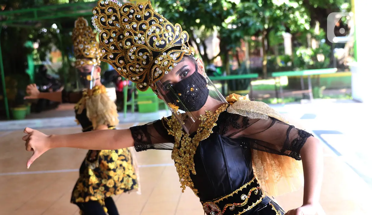 Penari tradisional dari Sanggar Eschoda melakukan latihan menggunakan masker dan pelindung wajah di Kota Tangerang, Jumat (12/6/2020). Para penari itu menerapkan protokol kesehatan jelang new normal atau tatanan hidup normal, sekaligus sebagai upaya pencegahan Covid-19. (Liputan6.com/Angga Yuniar)