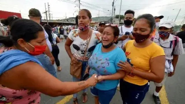 Kerabat para tahanan di penjara Zone 8 Deprivation of Liberty Center terlihat menunggu kabar, di Guayaquil [Marcos Pin Mendez/AFP] ​