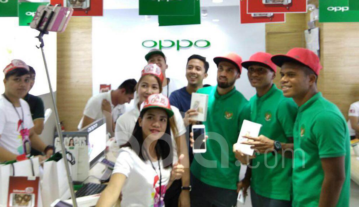 Stefano Lilipaly, M. Abduh Lestaluhu, dan Manahati Lestusen, berselfie dengan penjaga gerai telepon seluler di sebuah pusat perbelanjaan di Makati City, Manila, Filipina, Minggu (20/11/2016). (Bola.com/Nicklas Hanoatubun)