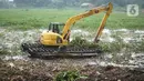 Petugas menggunakan alat berat untuk mengeruk eceng gondok yang memenuhi permukaan Setu Pengarengan, Depok, Jawa Barat, Senin (16/12/2019). Pengerukan dilakukan untuk membersihkan Setu Pengarengan dari eceng gondok yang tumbuh selama kurang lebih satu tahun terakhir. (Liputan6.com/Immanuel Antonius)