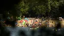 Orang-orang menikmati hari musim panas di danau Orankesee di Berlin, Jerman, Minggu (19/6/2022). Orang-orang berbondong-bondong ke taman dan kolam renang di seluruh Eropa Barat untuk sedikit mendinginkan tubuh mereka dari gelombang panas awal. (AP Photo/Markus Schreiber)