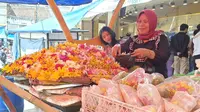 Dewi, salah satu penjual bunga rampes di Kawasan Pengkolan, Jalan A. Yani Garut, Jawa Barat tengah sibuk melayani pembeli. (Liputan6.com/Jayadi Supriadin)