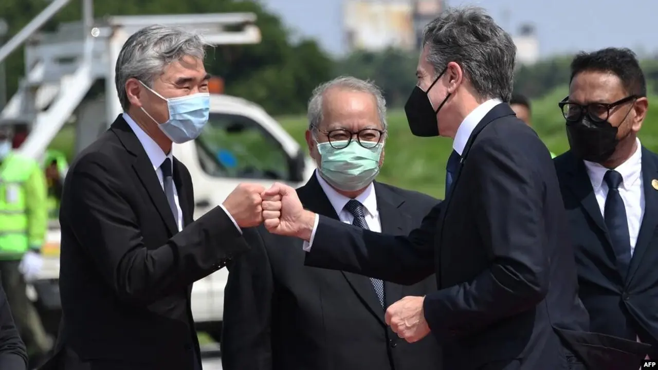 Menlu AS Antony Blinken (kanan) disambut oleh Dubes AS untuk Indonesia Sung Kim (kiri) setibanya di bandara internasional Soekarno-Hatta di Jakarta, 13 Desember 2021. (OLIVIER DOULIERY / POOL / AFP)