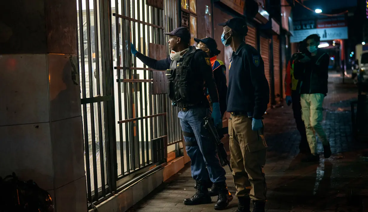 Petugas kepolisian Afrika Selatan berpatroli di pusat kota Johannesburg, Afrika Selatan, Jumat Jumat (27/3/2020). Polisi dan tentara mulai berpatroli beberapa saat setelah Afrika Selatan melakukan Lockdown 21 Hari dalam upaya untuk mengurangi penyebaran Covid-19. (AP Photo/Jerome Delay)