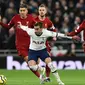 Gelandang Tottenham, Harry Winks, berusaha melewati gelandang Liverpool, Georginio Wijnaldum, pada laga Premier League di Stadion Tottenham, London, Sabtu (11/1). Tottenham kalah 0-1 dari Liverpool. (AFP/Glyn Kirk)