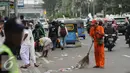 Petugas kebersihan DKI Jakarta membersihkan ceceran sampah di Silang Tenggara Monas, Jakarta, Jumat (14/10). Sebelumnya, ribuan massa ormas berunjuk rasa mendesak mundur Gubernur DKI Jakarta, Basuki Tjahaja Purnama. (Liputan6.com/Helmi Fithriansyah)