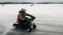 Pembalap tim Inggris, Cool Mowings berkompetisi dalam kejuaran balap mesin potong rumput tahunan di Lavia, Finlandia, 9 Februari 2019. Mereka harus menyelesaikan sebanyak mungkin putaran di area pertandingan yang tertutup salju. (Alessandro RAMPAZZO/AFP)