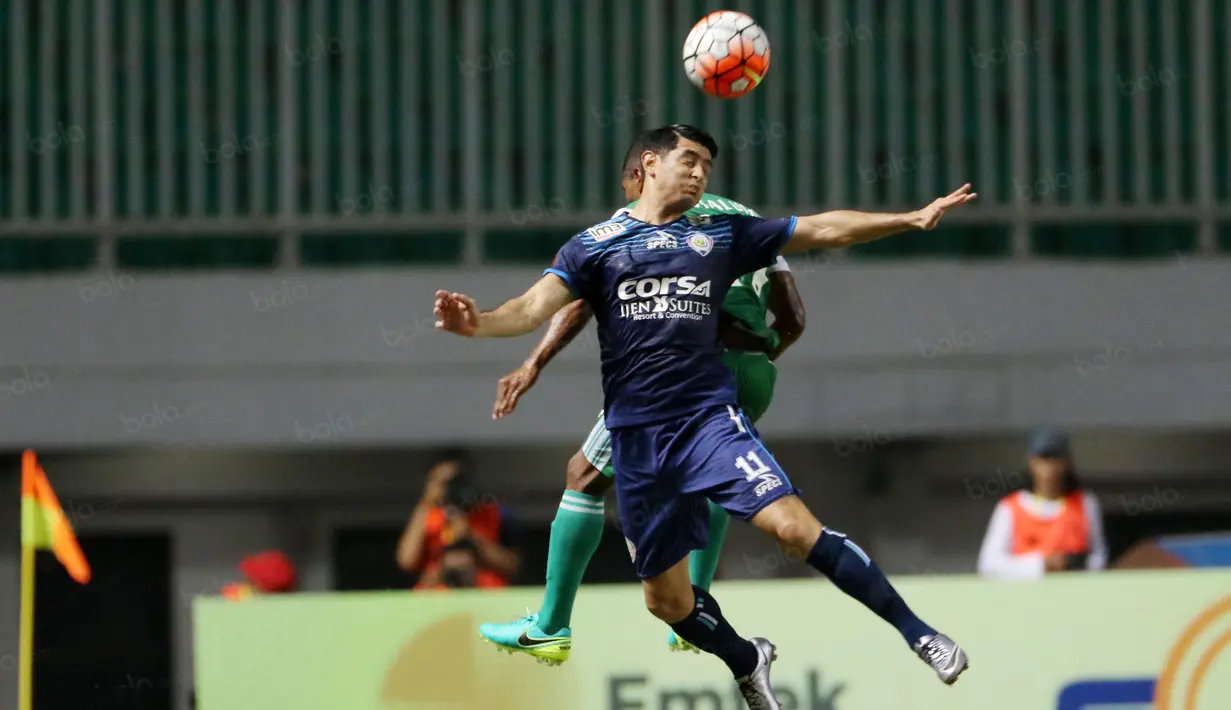 Pemain Arema Cronus, Esteban Vizcara berebut bola dengan pemain PS TNI, Abdu Lestaluhu pada laga Torabika SC 2016 di Stadion Pakansari, Bogor, Minggu (31/7/2016). (Bola.com/Nicklas Hanoatubun)