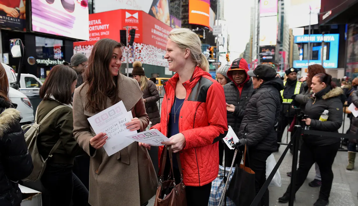 Sejumlah orang antre membawa kertas berisi pesan yang ingin dihancurkan pada "Good Riddance Day" di Times Square New York, Rabu (28/12). Warga berkumpul untuk membuang benda-benda yang ingin mereka lupakan di tahun yang baru. (REUTERS/Darren Ornitz)