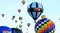 Seperti apa keindahan puluhan balon udara mengudara bersama-sama di langit pagi hari yang cerah?