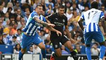 Gelandang Man City, Rodri, berebut bola dengan bek Brighton, Lewis Dunk, dalam laga Premier League di AMEX Stadium, Minggu (31/8/2025). (JUSTIN TALLIS / AFP)