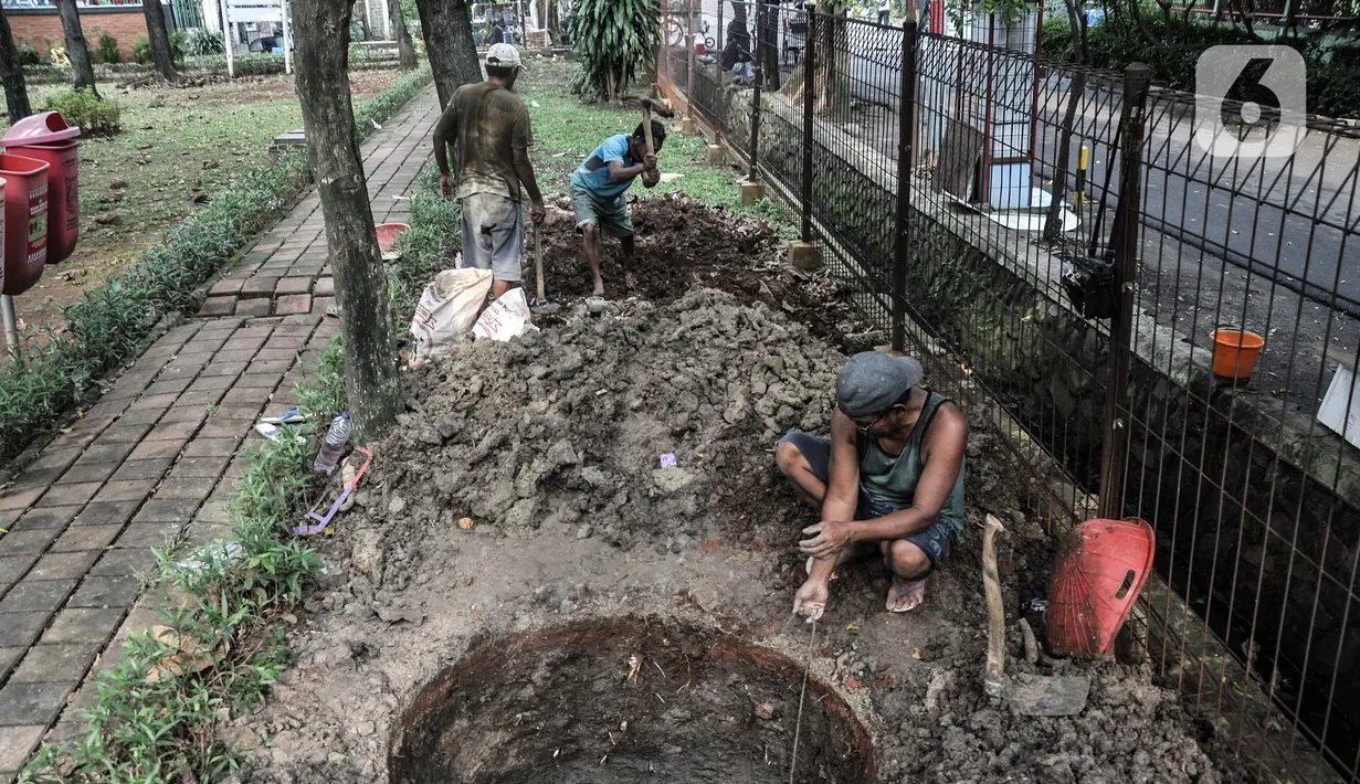 Pekerja menyelesaikan pembangunan sumur resapan di RPTRA Meruya Utara, Jakarta, Selasa (25/1/2022). Pembangunan 100 titik sumur resapan ini bertujuan untuk mengantisipasi banjir yang kerap terjadi di wilayah tersebut. (merdeka.com/Iqbal S. Nugroho)