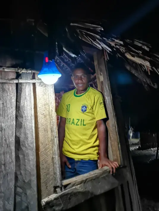 Warga berdiri dekat Lampu Tenaga Surya Hemat Energi (LTSHE) di Distrik Puldama, Kabupaten Yahukimo, Provinsi Papua. Nyala LTSHE adalah asa untuk masa  depan lebih baik bagi anak-anak Puldama. (Liputan6.com/HO/Hadi M Juraid)