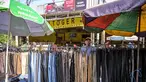 Seorang pedagang menata celana panjang sambil menunggu pelanggan pakaiannya di salah satu ruas jalan, Surabaya, Jawa Timur, pada Minggu 19 April 2026. Badan Pusat Statistik (BPS) Republik Indonesia akan melaksanakan Sensus Ekonomi 2026 (SE2026). (JUNI KRISWANTO/AFP)