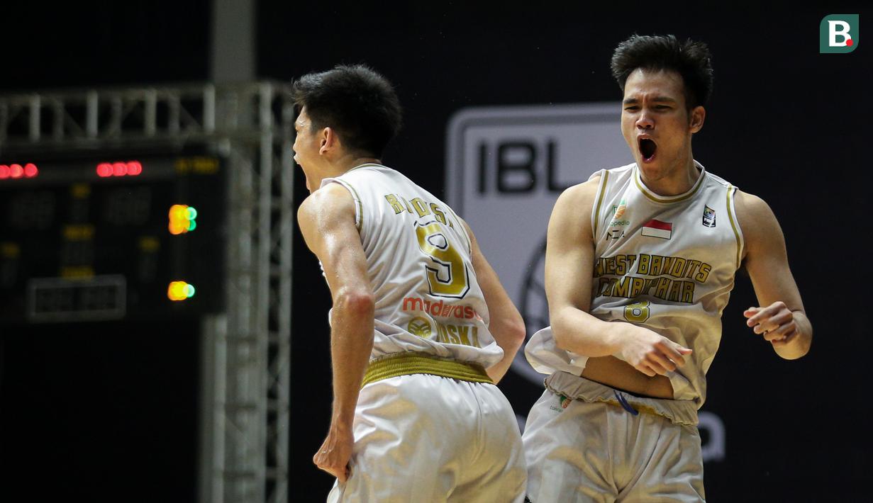 Pemain West Bandits Combiphar Solo, P. Nikolas (kanan) dan R. Disi melakukan selebrasi usai mencetak poin saat laga pekan pertama IBL Tokopedia 2022 melawan Rans PIK Basketball di Hall Basket Gelora Bung Karno, Senayan, Sabtu (15/01/2022). (Bola.com/Bagaskara Lazuardi)