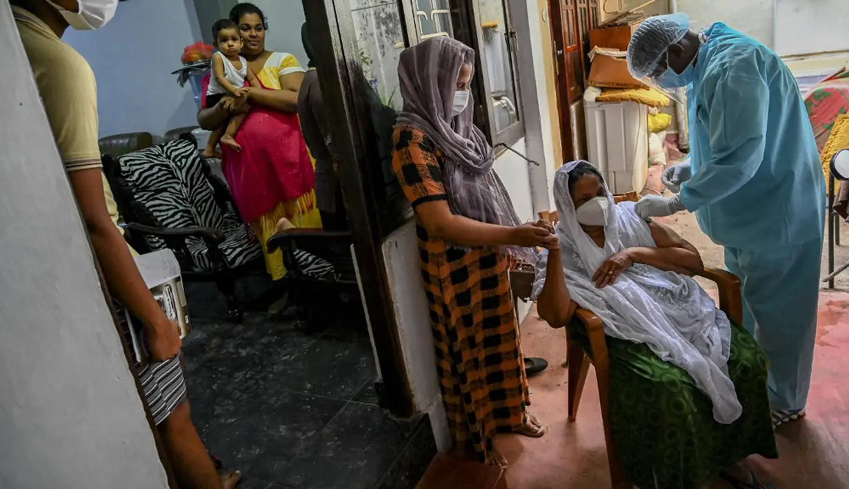 Seorang petugas kesehatan tentara (kanan) menyuntik seorang wanita dengan dosis virus corona COVID-19 saat vaksinasi keliling di Kolombo Sri Lanka, Kamis (12/8/2021). (Ishara S. KODIKARA/AFP)