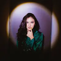 Pada potret lain, Mahalini Raharja mengunggah potret dirinya dengan sorotan cahaya lampu berbentuk lingkaran. Tampilan effortless dengan kemeja satin berwarna hijau serta rambut messy wave yang membuatnya tampil seksi seperti Kylie Jenner. (instagram/mahaliniraharja)