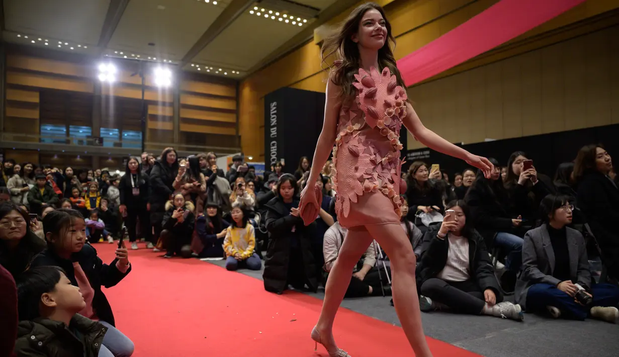 Seorang model berjalan di catwalk saat memperagakan gaun terbuat dari cokelat dalam pameran tahunan 'Salon du Chocolat' di Seoul, Korea Selatan (10/1/2020). (AFP Photo/Ed Jones)
