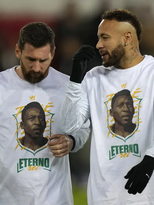 Penyerang PSG Lionel Messi berbicara dengan Neymar mengenakan kaos dengan potret mendiang legenda sepak bola Brasil Pele sebelum lanjutan Liga Prancis 2022/2023 melawan Angers di Parc des Princes, Kamis (12/1/2023) dini hari WIB. Messi dan kawan-kawan kompak menggunakan kaos putih bertuliskan ‘ETERNO’ yang berarti abadi dengan gambar Pele di depannya (AP Photo/Francois Mori)