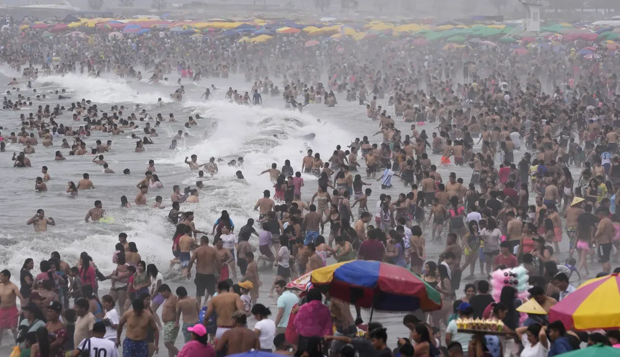 Ribuan orang bersenang-senang di pantai Agua Dulce di Lima, Peru, Minggu (29/1/2023). Peru berada di tengah gejolak politik sejak mantan Presiden Pedro Castillo dimakzulkan dan ditangkap karena mencoba membubarkan Kongres dan digantikan oleh Wakil Presidennya Dina Boluarte, yang memicu protes keras. (AP Photo/Martin Mejia)