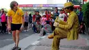 Seorang pengunjung dari luar negeri tampak penasaran aksi manusia patung yang duduk pada bangku yang tak terlihat (Liputan6.com/Miftahul Hayat)