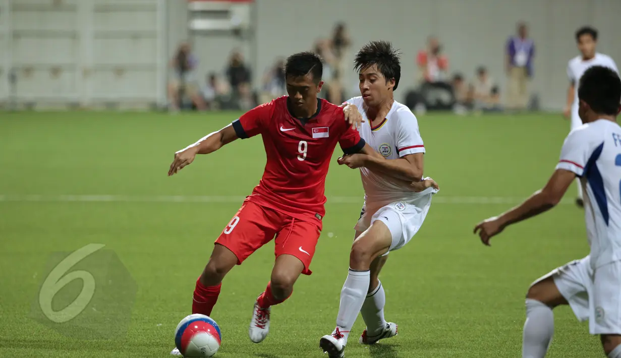 Gelandang timnas Singapura U-23, A R Pristifana Samion (kiri) berusaha lolos dari kawalan dua pemain Filipina di laga grup A Sea Games 2015 di Stadion Jalan Besar, Singapura, Senin (1/6/2015). Singapura unggul 1-0. (Liputan 6.com/Helmi Fithriansyah)   