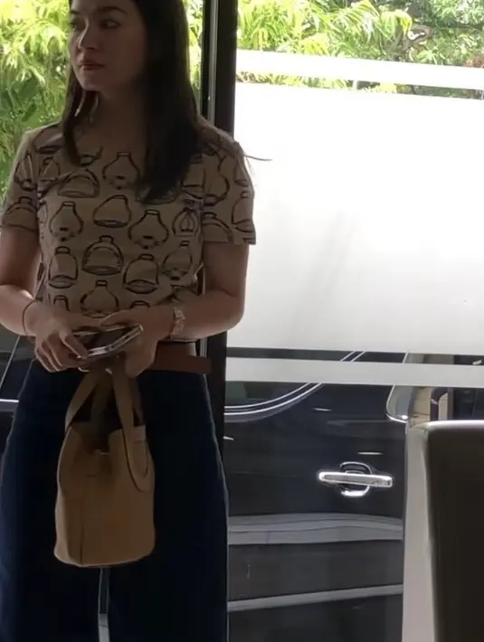 T shirt model micro dengan printed cotton jersey tersebut warna coklat dengan motif abstrak. Diketahui t shirt made in Prancis tersebut seharga Rp11 jutaan. Kaos tersebut dipadukan belt coklat dan celana denim. Sambil membawa handbag coklat dari Hermes.  [@ironhairspecialist]