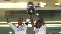 Bek Real Madrid, Sergio Ramos dan Marcelo mengangkat trofi Piala Super Spanyol 2017 usai pertandingan melawan Barcelona di stadion Santiago Bernabeu, Spanyol (16/8). Real Madrid menang 2-0 atas Barcelona dengan skor agregat 5-1. (AP Photo/Francisco Seco)