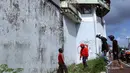 Sejumlah warga mengamati lubang yang digunakan narapidana asing untuk kabur dari Lapas Kerobokan, Bali, Senin (19/6). Empat narapidana asing kabur masih diburu petugas setelah meloloskan diri dari lapas melalui terowongan tersebut. (AP /Firdia Lisnawati)