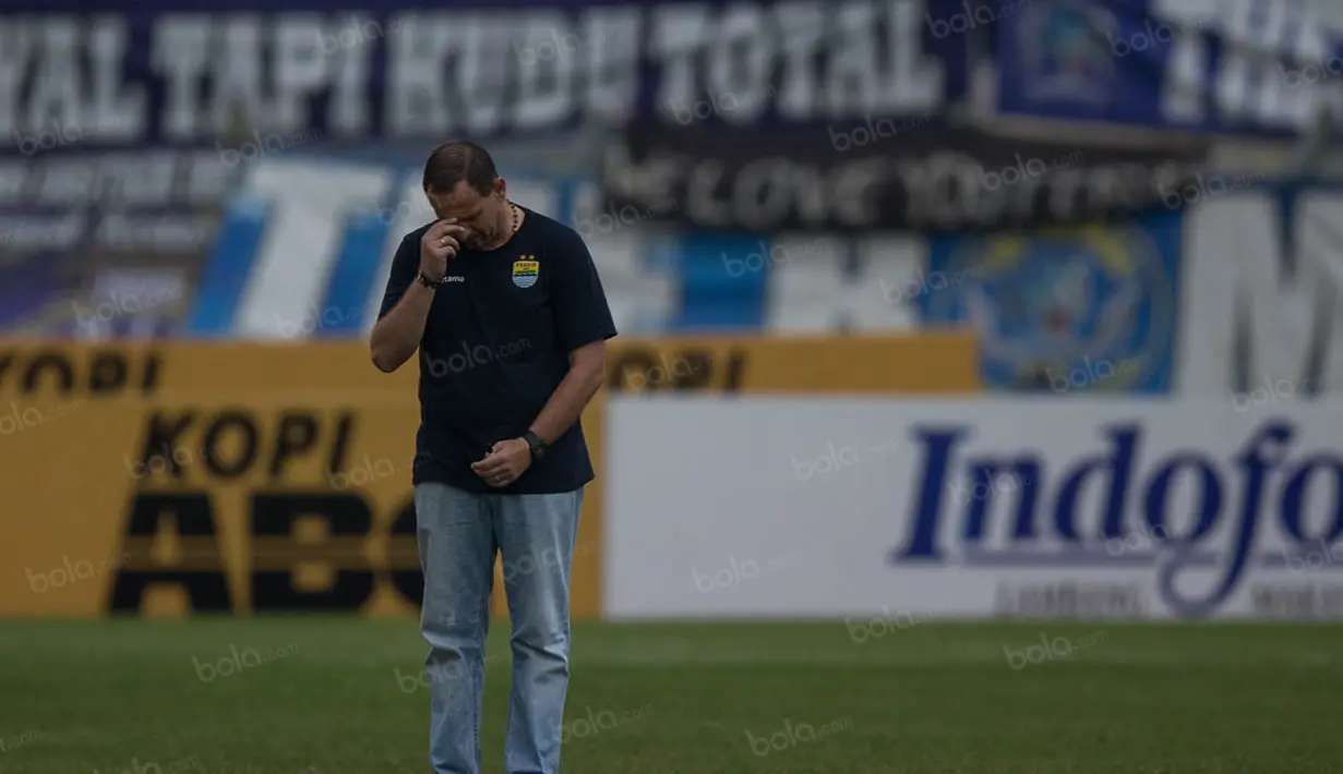 Pelatih Persib, Dejan Antonic, membuat tanda salib sesuai ajaran agama Katolik sebelum laga melawan Madura United. (Bola.com/Vitalis Yogi Trisna)