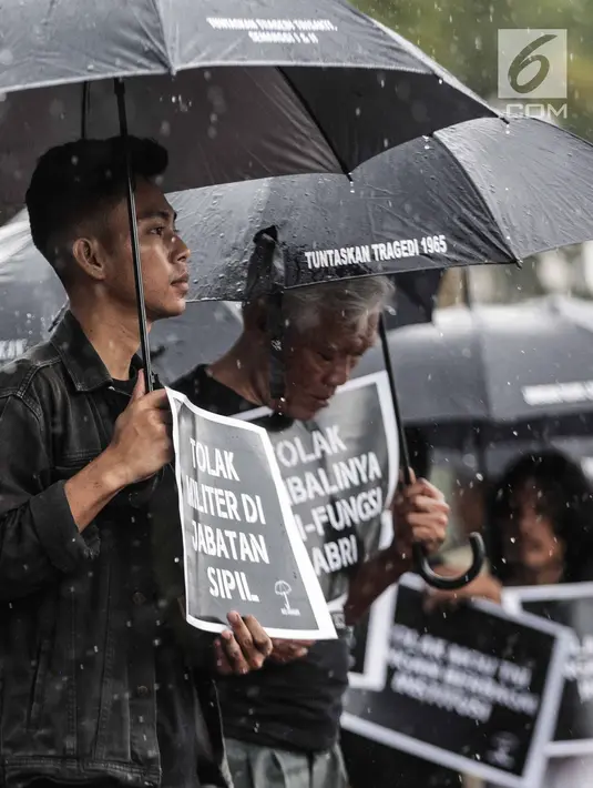 Hujan mengguyur saat aktivis Jaringan Solidaritas Korban untuk Keadilan (JSKK) menggelar aksi Kamisan ke-575 di depan Istana Merdeka, Jakarta, Kamis (21/2). Aktivis menolak kembalinya militer untuk menduduki jabatan sipil. (Liputan6.com/FaizalFanani)