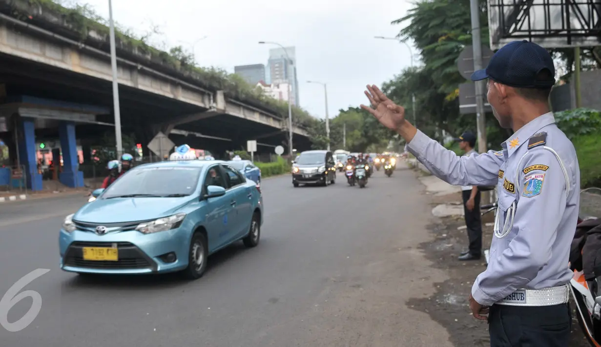 Petugas Dishub mengatur kendaraan yang melintasi Jalan TB Simatupang, Jakarta, Senin (12/12). Dinhubtrans Jaksel menyiagakan petugas di sejumlah titik rawan kemacetan untuk antisipasi penumpukan kendaraan saat arus balik. (Liputan6.com/Yoppy renato)